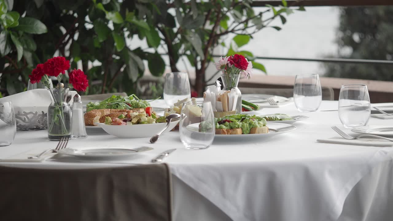Set Meja Restoran Outdoor Elegan dengan Makanan dan Bunga