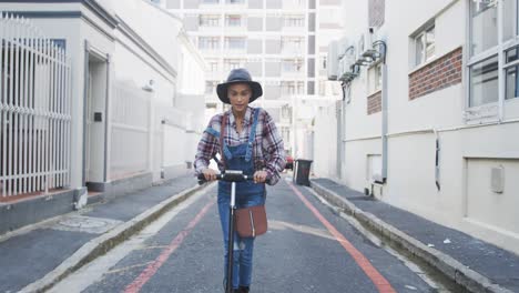 mixed race woman using electric scooter