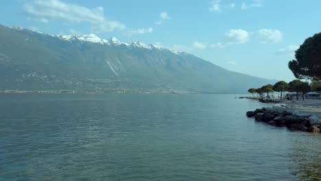 Atemberaubendes-Panorama-Des-Gardasees-Mit-Schneebedeckten-Bergen,-Weitem-Himmel-Und-Ruhigem-Wasser,-Das-Die-Schönheit-Der-Natur-In-Venetien,-Italien,-Zur-Schau-Stellt