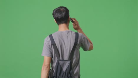 전화로 얘기하는 오버얼을 입은 남자