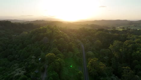 Drone-shot-of-hilly-terrain-in-Cooroy-Noosa,-with-the-Glass-House-Mountains-in-background