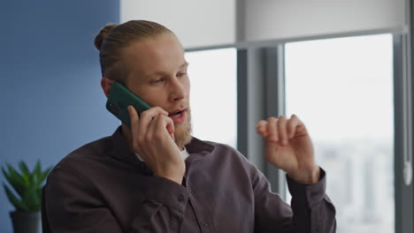 serious manager talking phone office interior portrait. man calling smartphone