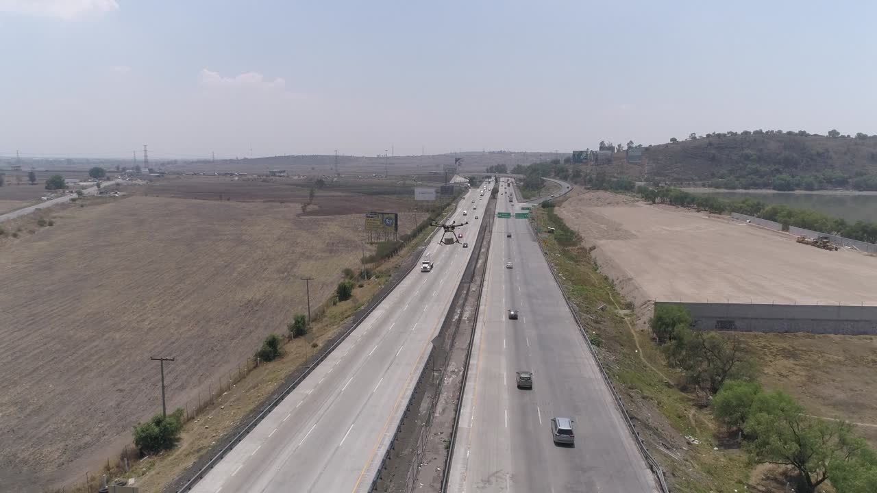 대형 법 집행 드론이 고속도로 위에서 차량을 스캔하는 공중 총격