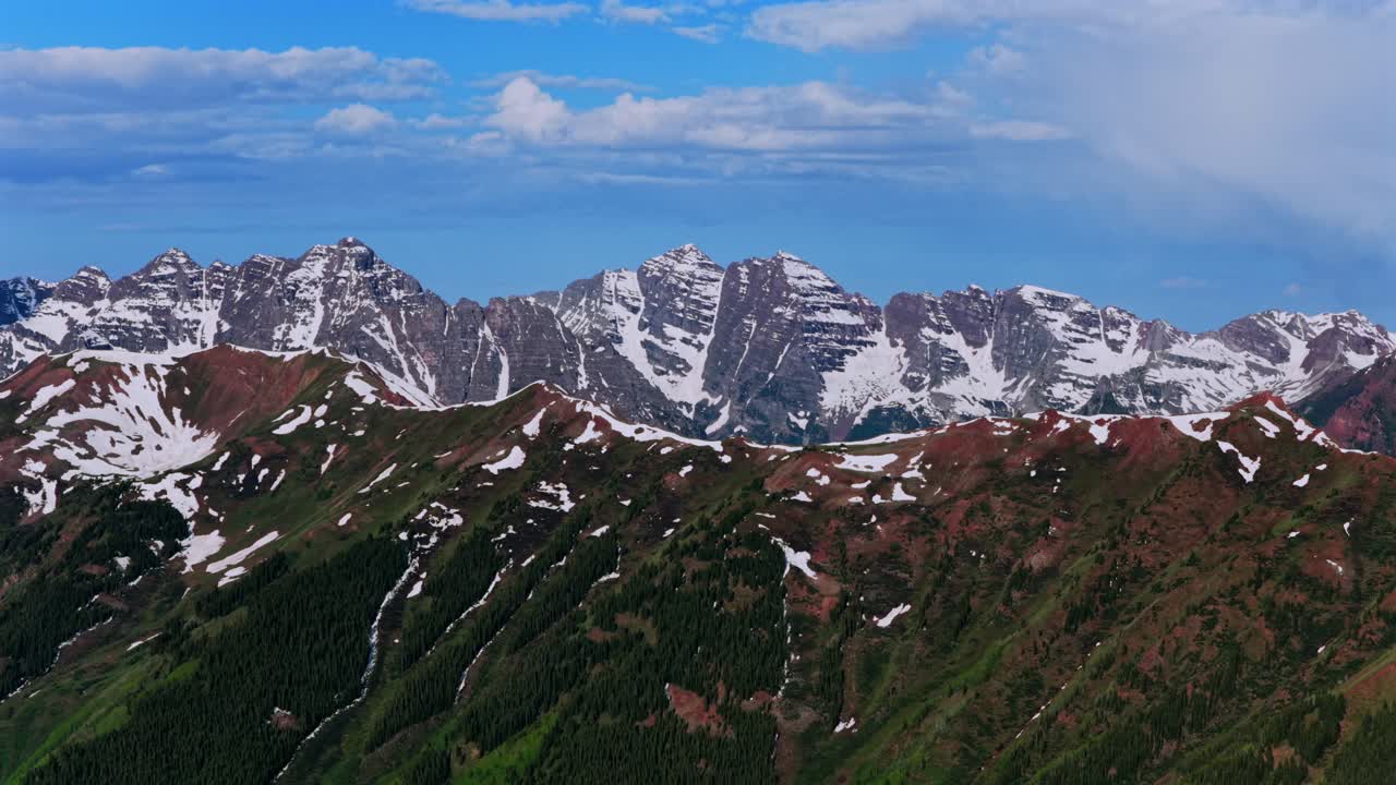 Summit of Pyramid Peak Maroon peak North Maroon Bells Wilderness aerial drone parallax left Colorado panorama Aspen Highlands bowl spring summer sunny morning blue sky clouds Rocky Elk Mountain Range