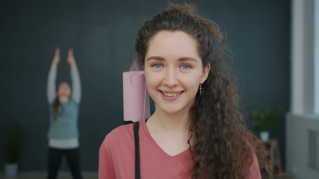 Smiling Woman Carrying Yoga Mat During Class