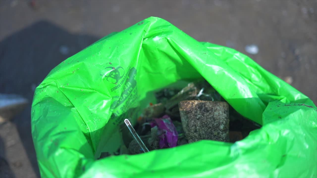 쓰레기 가방 에 쓰레기 가방 을 넣는다.  ⁇ 바이 의 마임 비치 의 근접 사진