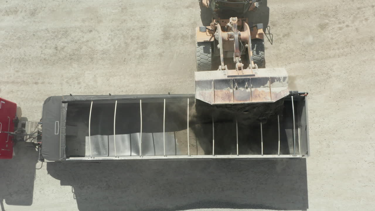 앞 로더 가 석회암 을 덤프 트럭 에  ⁇ 는 장면