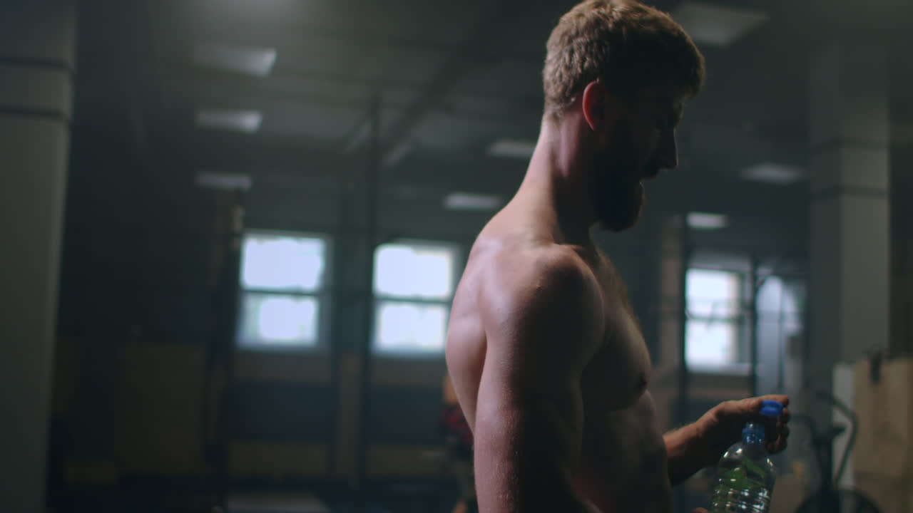 un uomo stanco in palestra si sta riposando dopo aver eseguito un esercizio. fai una pausa dopo l'allenamento.