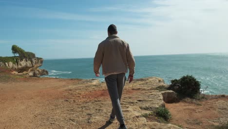 hermoso fondo de la costa, joven caminando hacia el borde