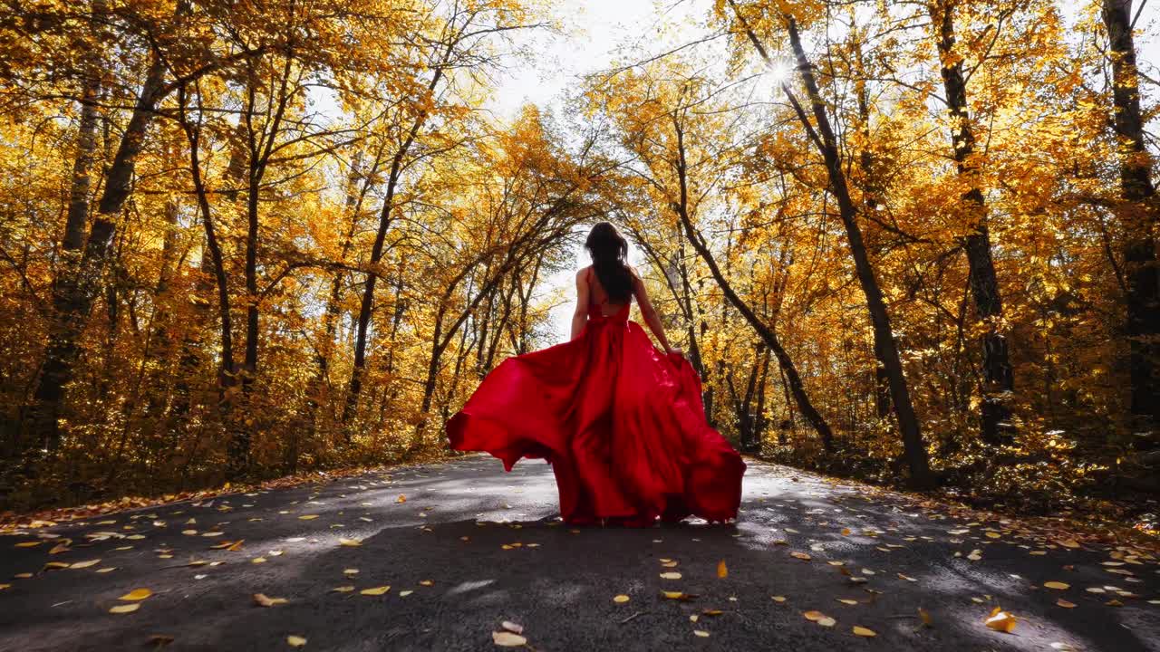 A Majestic Figure in a Flowing Red Dress Gracefully Walks Through a Sunlit Autumn Forest, Surrounded by Golden Leaves and a Serene Pathway