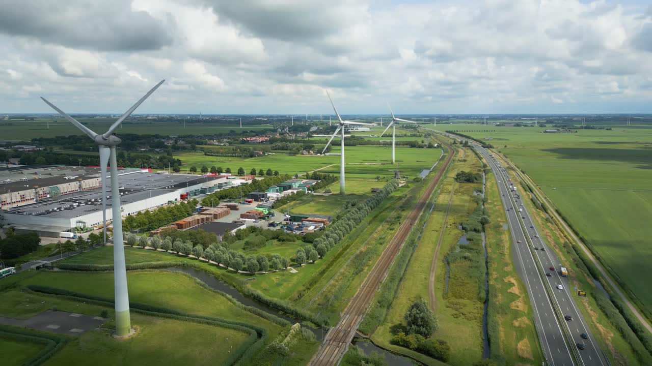 High aerial drone clip of wind turbines along roads and canals in an agricultural Dutch setting