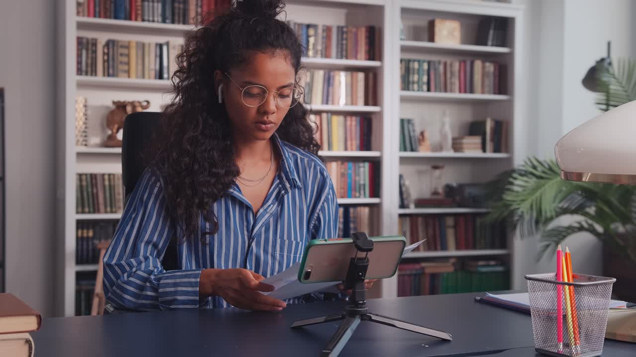 Young indian woman in video call online conference by phone talking to colleague