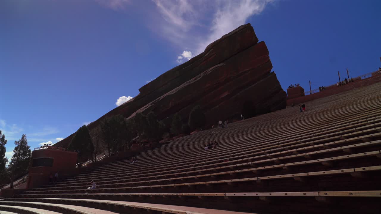 Red Rocks Park and Amphitheater band music staircase stage Morrison Colorado aerial drone forward pan up motion mid winter sunny blue sky clouds tourist destination large sandstone feature