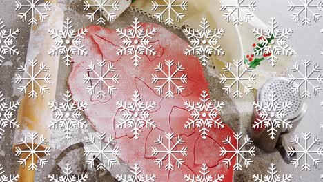 animation of snowflakes over cookies dough and mold
