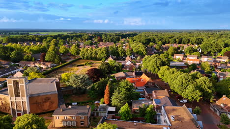 green homes in a lush suburb. aerial view of a peaceful suburban area surrounded by trees at sunset, showcasing houses and quiet streets