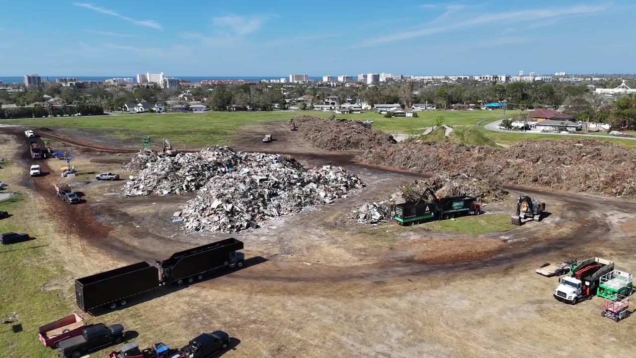 large lawn waste disposal truck contractors dump their collection at a temporary FEMA waste dump after Hurrican Milton in Sarasota, Florida