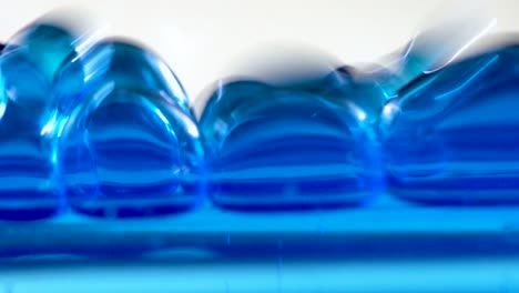 blue gel bubbles falling abstract macro