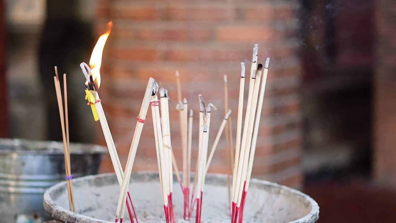 palos de incienso ardiendo en una olla