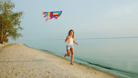 carefree girl runs along the beach playing with a kite steadicam slow motion shot