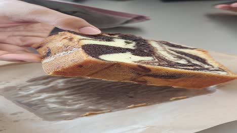 person holding a slice of chocolate marble cake