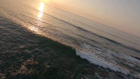 Drone-flying-at-low-altitude-along-rocky-cliff-at-sunset,-Hendaye,-Pyrenees-Atlantiques,-France