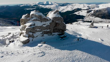 aerial, orbit, drone shot around the sphinx rock formation, on the top of the southern carpathians, on a sunny winter day, in the bucegi natural park, romania