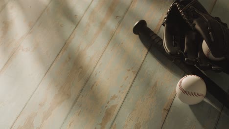 overhead studio baseball still life with bat ball and catchers mitt on aged wooden floor