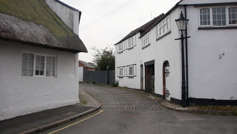 victorian road cobbled street establishing shot in an english village with white buildings and iron lamp posts