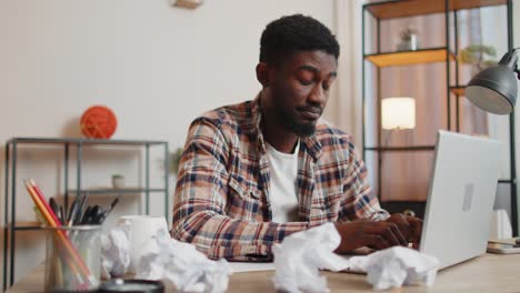 angry furious man working at home office throwing crumpled paper, having nervous breakdown at work