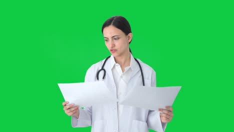 indian female doctor checking medical reports green screen