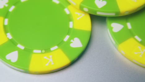 fichas de casino de color verde brillante para apuestas sobre un fondo gris claro