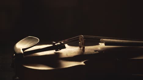 close up of old violin, dramatic light changes over the instrument , classical symphony music video footage