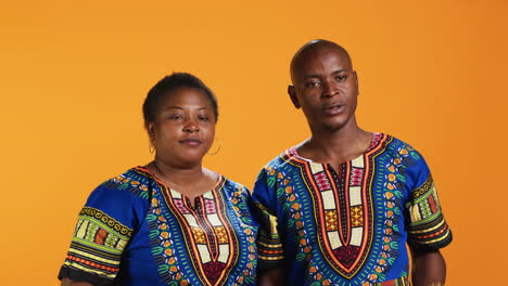 una pareja afroamericana haciendo un símbolo de parada con la palma de la mano