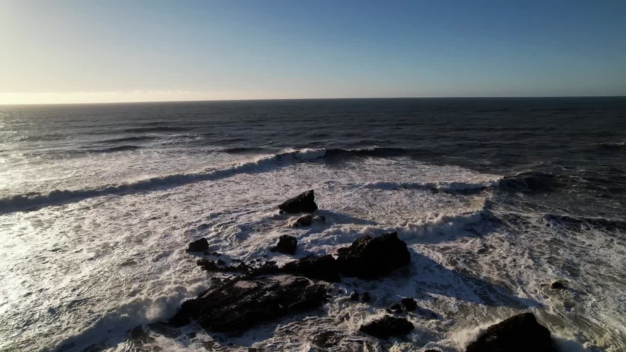 el dron sale sobre las rocas de marea oceánica en mavericks beach, california durante la puesta de sol