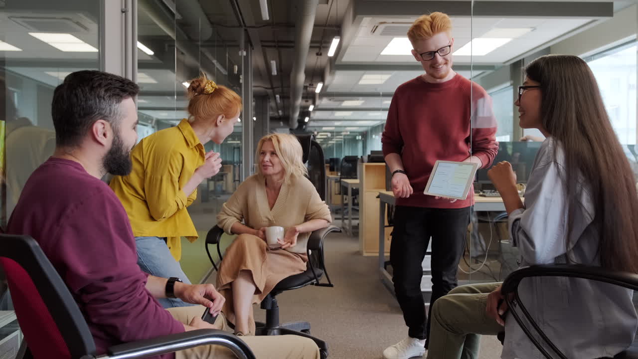 коллеги обсуждают работу, глядя на планшет.