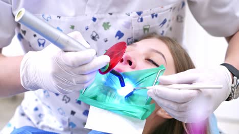 Dentist Working With Female Teeth. Dentist in stomatology center making examination of woman teeth by using dental tools