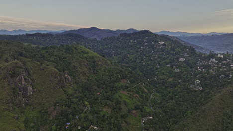 Ella-Sri-Lanka-Aerial-v14-cinematic-drone-flyover-verdant-valley-capturing-mountainous-landscape-and-small-village-town-nested-on-hilly-terrains-at-dawn---Shot-with-Mavic-3-Cine---April-2023