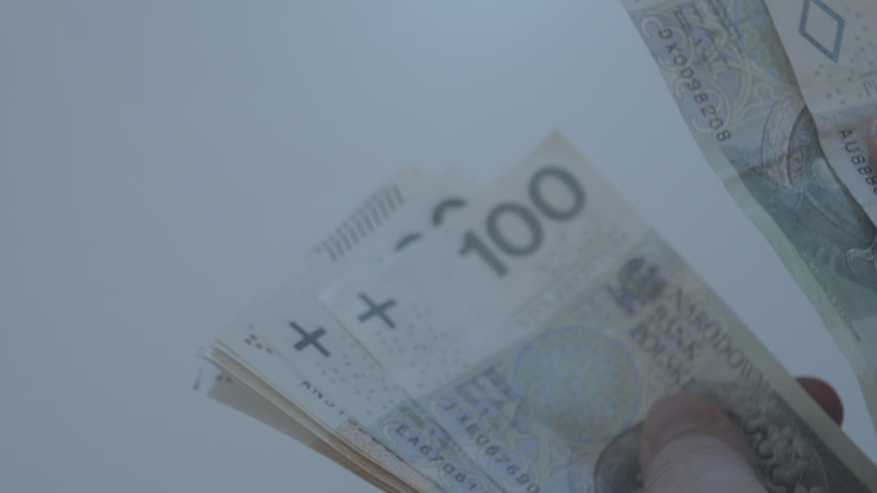 мужские руки пересчитывают банкноты польских злотых купюрами по 50 100 200