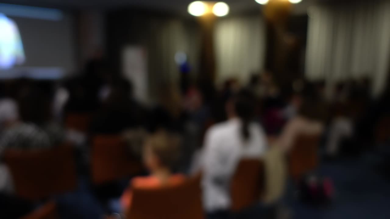 Lezione in aula con l'ausilio di uno schermo informativo. Sfocato.