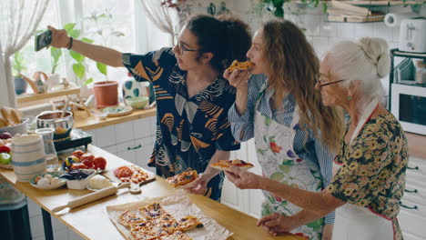 multigenerational family eating homemade pizza and taking selfie in kitchen