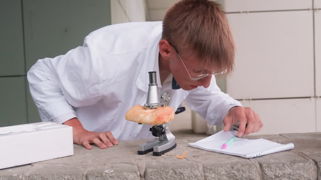 Scientific researcher in white coat rises up after carefully examining pastry through microscope outdoors, jotting discoveries with focus and curiosity, reflecting dedication