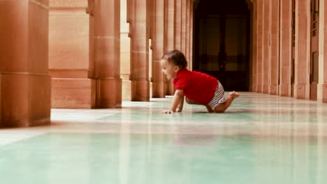 cute toddler crawling at gallery white marble floor at day
