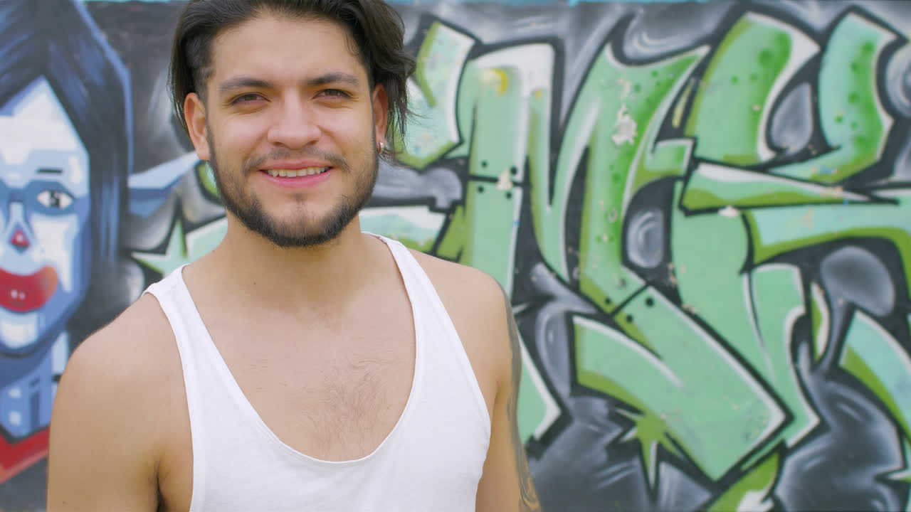 chico guapo bebiendo agua fresca de una botella de plástico en un parque de patinaje