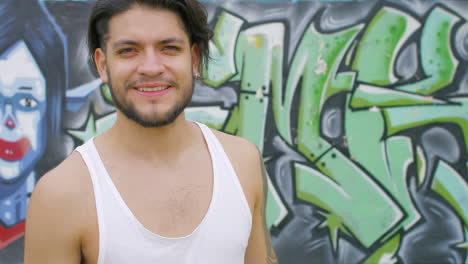 chico guapo bebiendo agua fresca de una botella de plástico en un parque de patinaje