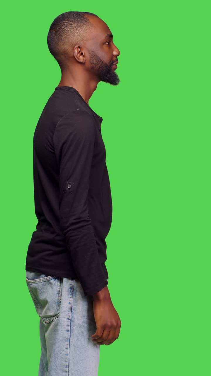 Vertical video: Profile of african american man feeling confident posing in studio