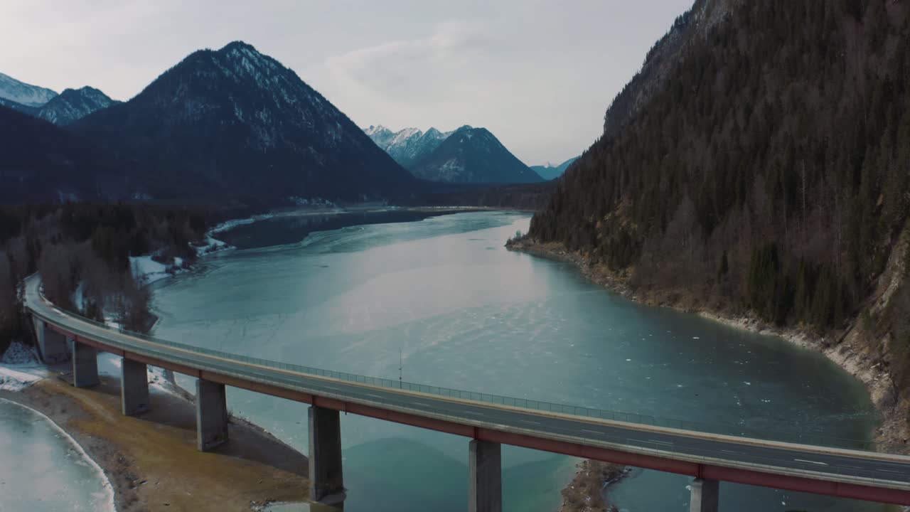 Anamorphic 4K Aerial Drone footage of the famous and scenic bridge across the Bavarian drinking water reserve lake Sylvenstein in southern Germany in the mountains.