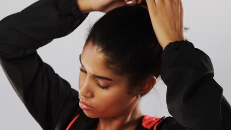 woman tying her hair against white background 4k