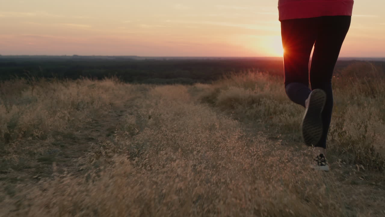 las piernas de una mujer corriendo al atardecer