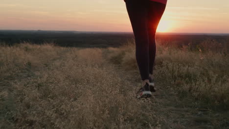 the legs of a woman running at sunset