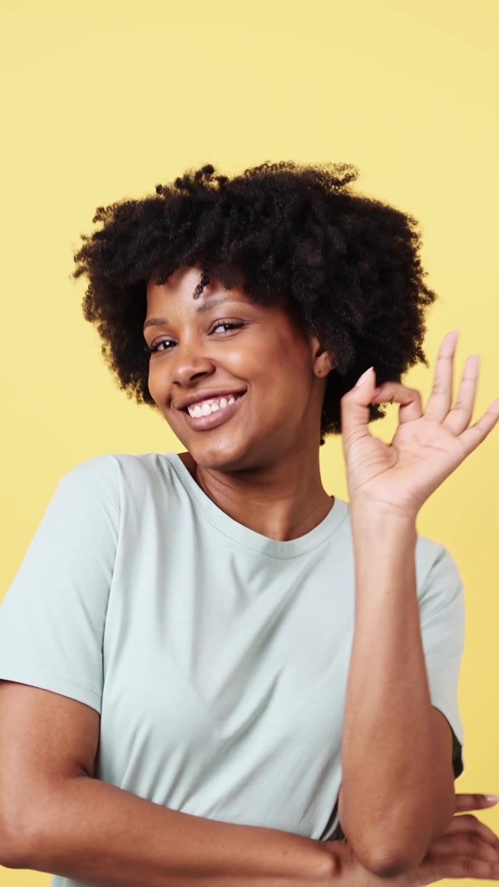 Donna afroamericana felice che fa il gesto dell'OK e fa l'occhiolino